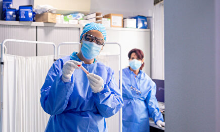 Personal sanitario manejando una probeta. | EFE