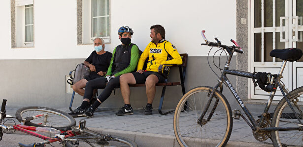 Los hermanos Primi (d) y Mario (c) y su tío Pedro (i), descansan junto a sus bicicletas en un banco | Carlos Castro / Europa Press