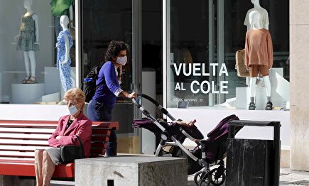 Una mujer camina frente a un escaparate con la campaña de la vuelta al colegio en una calle del centro de Oviedo, este viernes. | EFE
