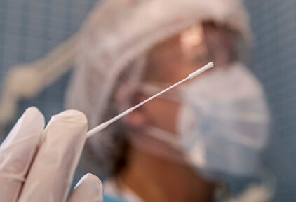 Una enfermera sostiene el bastoncillo de una prueba PCR. | EFE