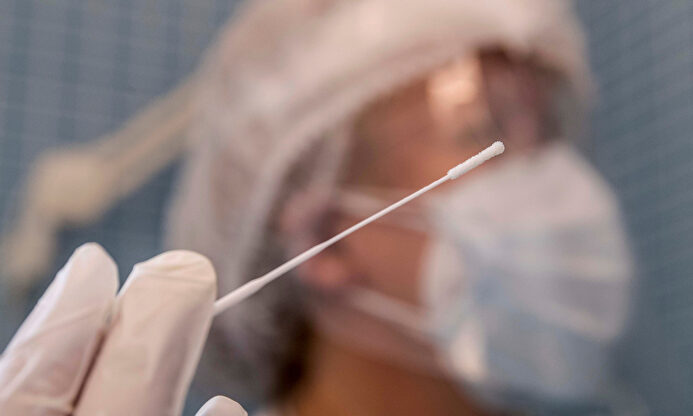 Una enfermera sostiene el bastoncillo de una prueba PCR. | EFE