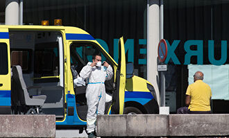 Un profesional sanitario baja de la ambulancia en la que viaja un paciente con Covid-19 | Carlos Castro / Europa Press