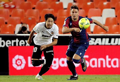 El delantero coreano del Valencia CF Kang-In Lee persigue el balón con el serbio Nemanja Radoja, del Levante. | EFE