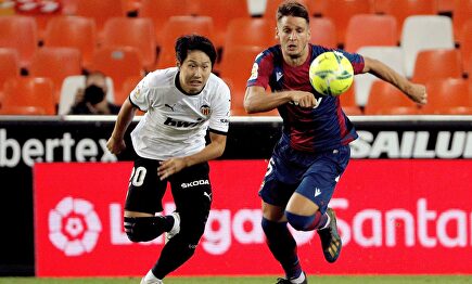 El delantero coreano del Valencia CF Kang-In Lee persigue el balón con el serbio Nemanja Radoja, del Levante. | EFE