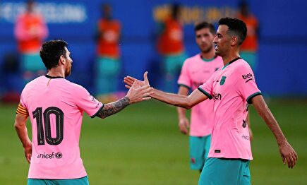 Leo Messi celebra con Busquets uno de sus dos goles al Girona. | EFE