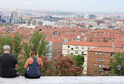 Dos personas observan el barrio desde el cerro del Tío Pío en Vallecas  | EFE