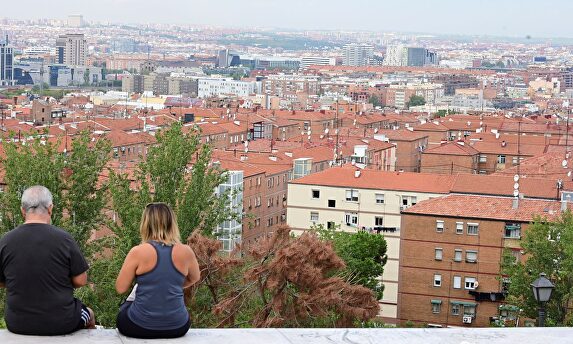 Dos personas observan el barrio desde el cerro del Tío Pío en Vallecas  | EFE