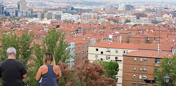 Dos personas observan el barrio desde el cerro del Tío Pío en Vallecas  | EFE