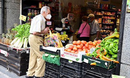 Vecinos del distrito del Puente de Vallecas hacen sus compras, este sábado, en una frutería en la Avenida de la Albufera. | EFE
