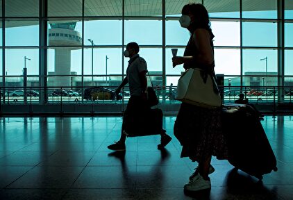 Viajeros con máscaras sanitarias caminan por la Terminal 1 del aeropuerto Josep Tarradelles - El Prat, en Barcelona. | EFE