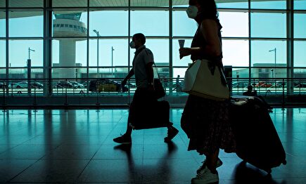 Viajeros con máscaras sanitarias caminan por la Terminal 1 del aeropuerto Josep Tarradelles - El Prat, en Barcelona. | EFE