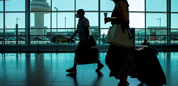 Viajeros con máscaras sanitarias caminan por la Terminal 1 del aeropuerto Josep Tarradelles - El Prat, en Barcelona. | EFE