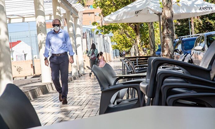 Un hombre camina junto a la terraza de un bar | JAVIER PULPO - EUROPA PRESS