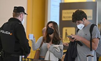 Un agente de la Policía Nacional controla el acceso a la T-4 del Aeropuerto Adolfo Suárez Madrid-Barajas, hoy viernes, para vigilar el cumplimiento de las restricciones a la movilidad impuestas por el estado de alarma que ha decretado el Gobierno. | EFE