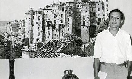 Raúl del Pozo, de joven, junto a una enorme imagen de Cuenca. | Archivo Raúl del Pozo