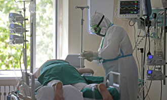 Un paciente y un sanitario en un hospital. | EFE