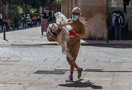 Trabajador de la construcción con equipo de protección caminando por una calle del centro de Barcelona durante el covid | Alamy