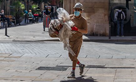 Trabajador de la construcción con equipo de protección caminando por una calle del centro de Barcelona durante el covid | Alamy