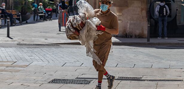 Trabajador de la construcción con equipo de protección caminando por una calle del centro de Barcelona durante el covid | Alamy