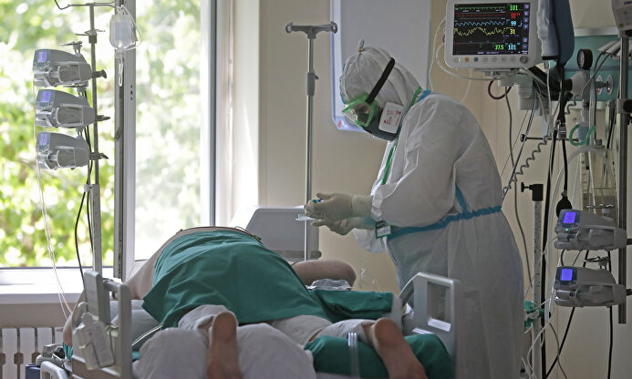 Un paciente y un sanitario en un hospital. | EFE