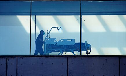 Un celador transporta una camilla en el hospital de Bellvitge, en Cataluña. | EFE