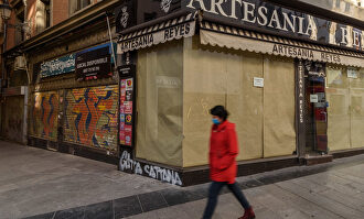 Una ciudadana camina por la calle Preciados de Madrid, ante comercios cerrados. | C.Jordá