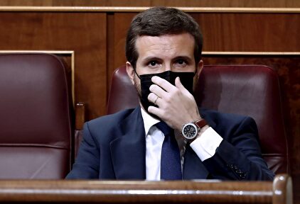 El líder del Partido Popular, Pablo Casado, se coloca la mascarilla mientras asisten a la moción de censura presentada por Vox al gobierno de coalición en el Congreso de los Diputados este miércoles | EFE