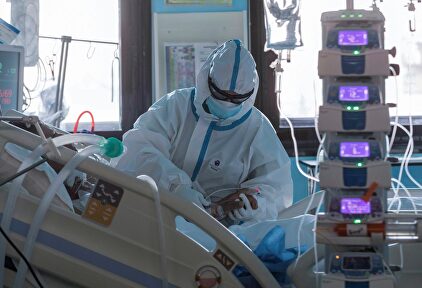 Sanitario atendiendo a una paciente de coronavirus en una UCI | EFE