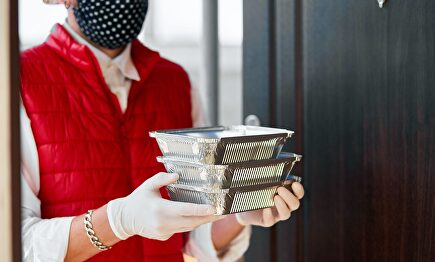 Un repartidor entregando el pedido | Alamy