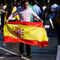 Un hombre posa con una bandera de España mientras se deja tomar una fotografía al finalizar el desfile.