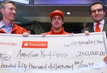 Fernando Alonso entrega un cheque a Cruz Roja. | Santander.com