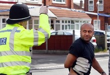 Un polica habla con los vecinos junto al lugar del crimen | EFE
