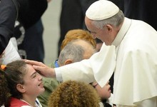 El Papa acaricia a un nio.