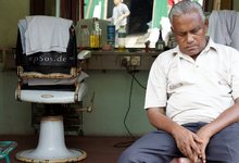Un hombre duerme frente a una peluquería | Archivo