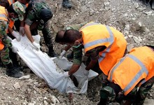 Miembros de la defensa civil de Siria removiendo un cuerpo de una tumba comn. | Efe