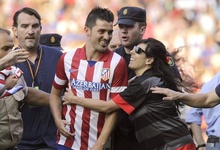 David Villa es abrazado por una aficionada al salir custodiado del Vicente Calder�n tras su presentaci�n. | EFE
