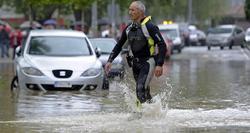 Un bombero atraviesa una de las calles inundadas en el barrio de la Rochapea de Pamplona | EFE