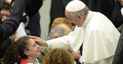El Papa acaricia a un nio.