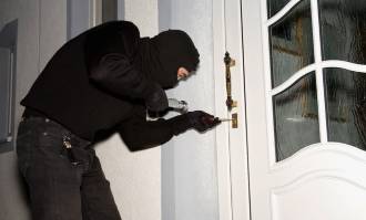 Imagen de un ladrón robando en una casa.