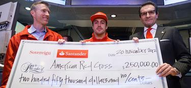 Fernando Alonso entrega un cheque a Cruz Roja. | Santander.com