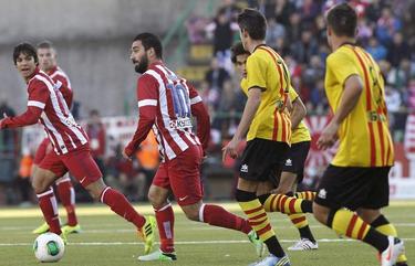Arda Turan (c) conduce la pelota ante varios jugadores del Sant Andreu. | EFE