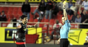 El rbitro Gonzlez Gonzlez muestra la amarilla a Diego Costa durante el Sevilla-Atltico de Madrid. | Cordon Press