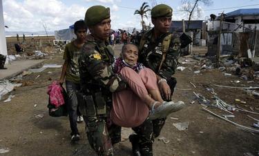 Soldados filipinos trasladando a una mujer mayor en la zona de Tacloban | EFE