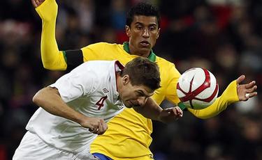 Paulinho, con la seleccin brasilea, disputa un baln con Gerrard. | EFE