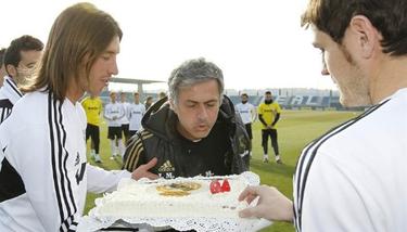 Mourinho sopla las velas de la tarta que le trajeron Ramos y Casillas. | EFE