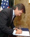 Bernardino Len firmando en la embajada de EEUU.